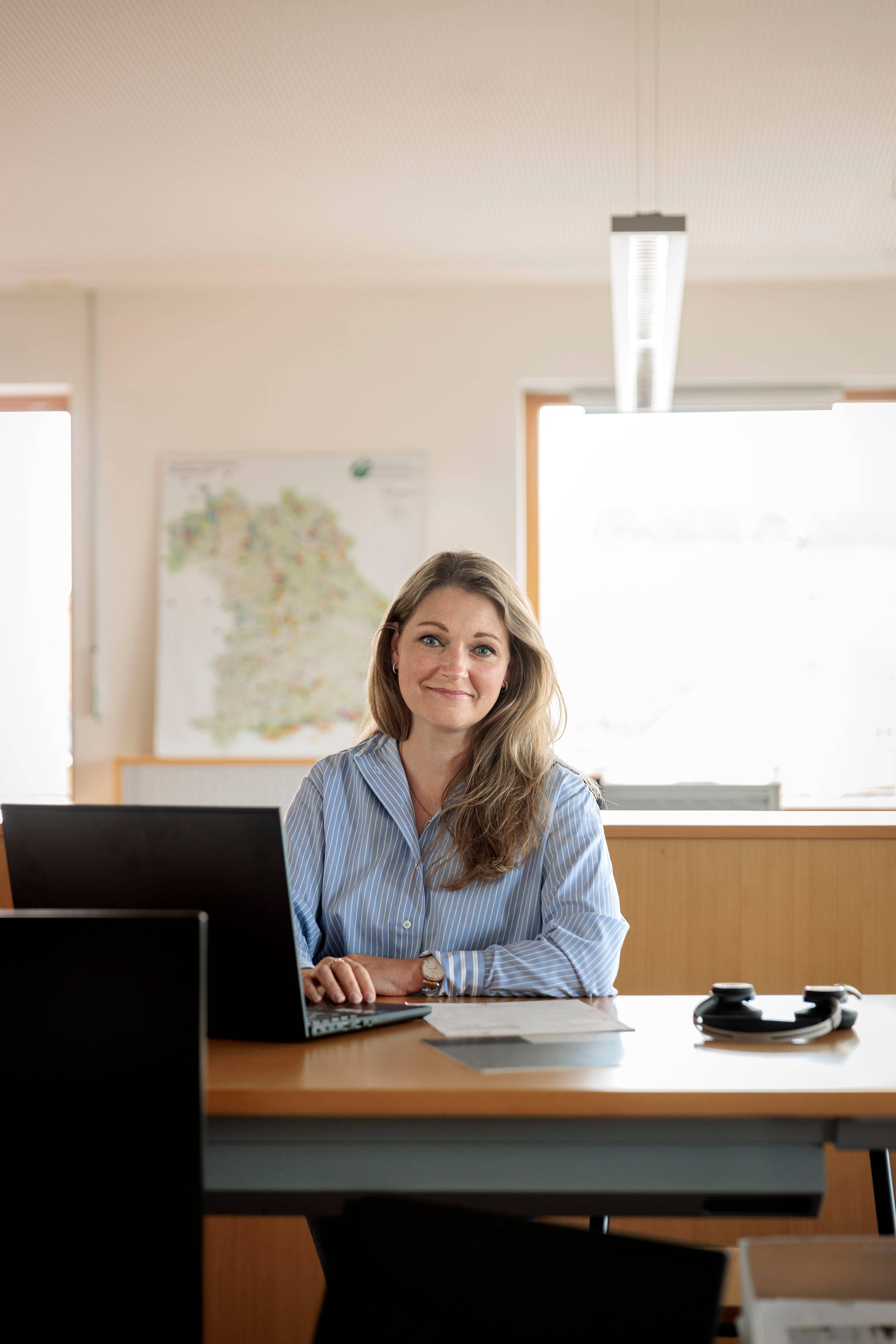 Frau hockt in Büro am Schreibtisch