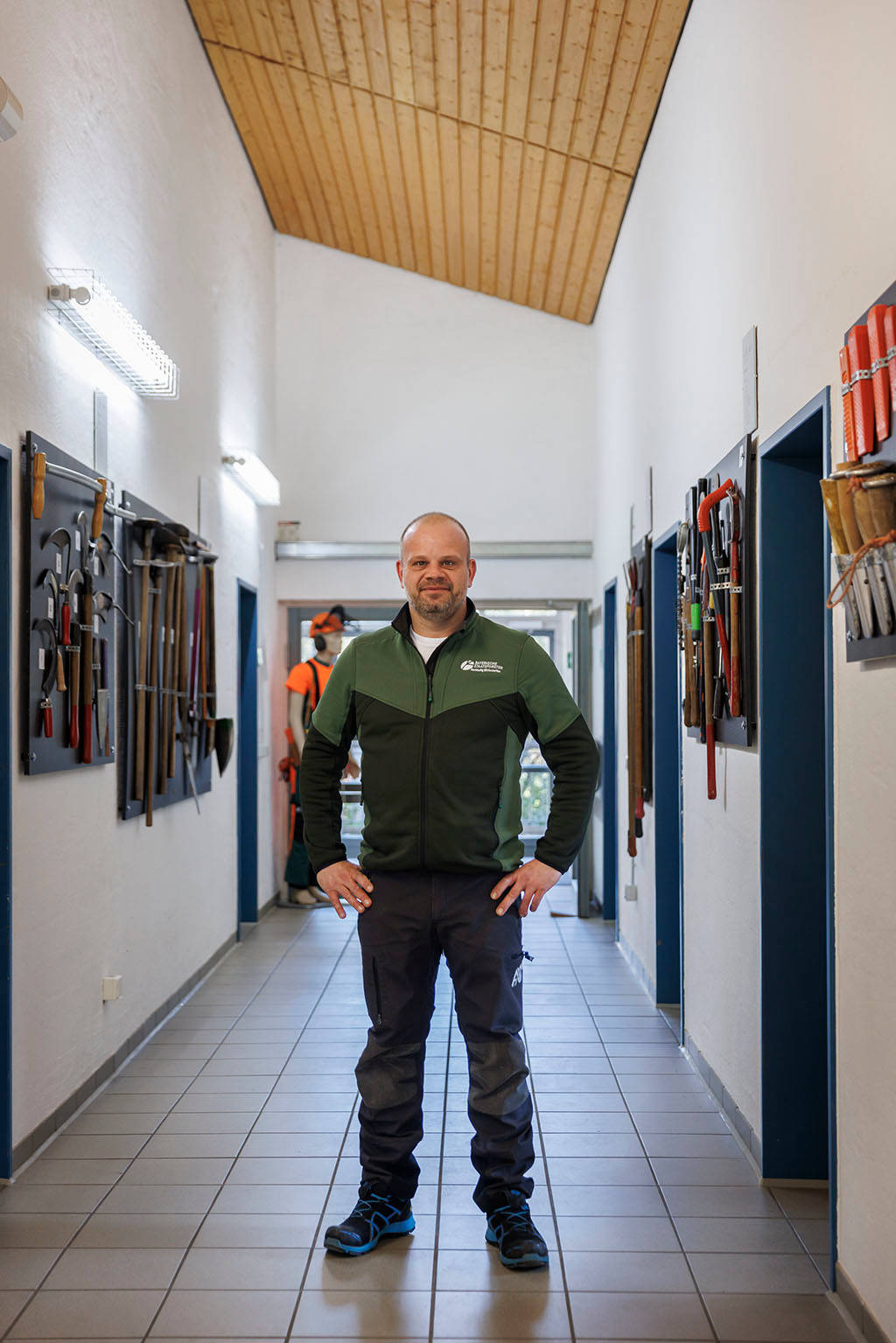 Forstwirtschaftsmeister Ausbilder steht in Ausbildungshalle für Forstwirte