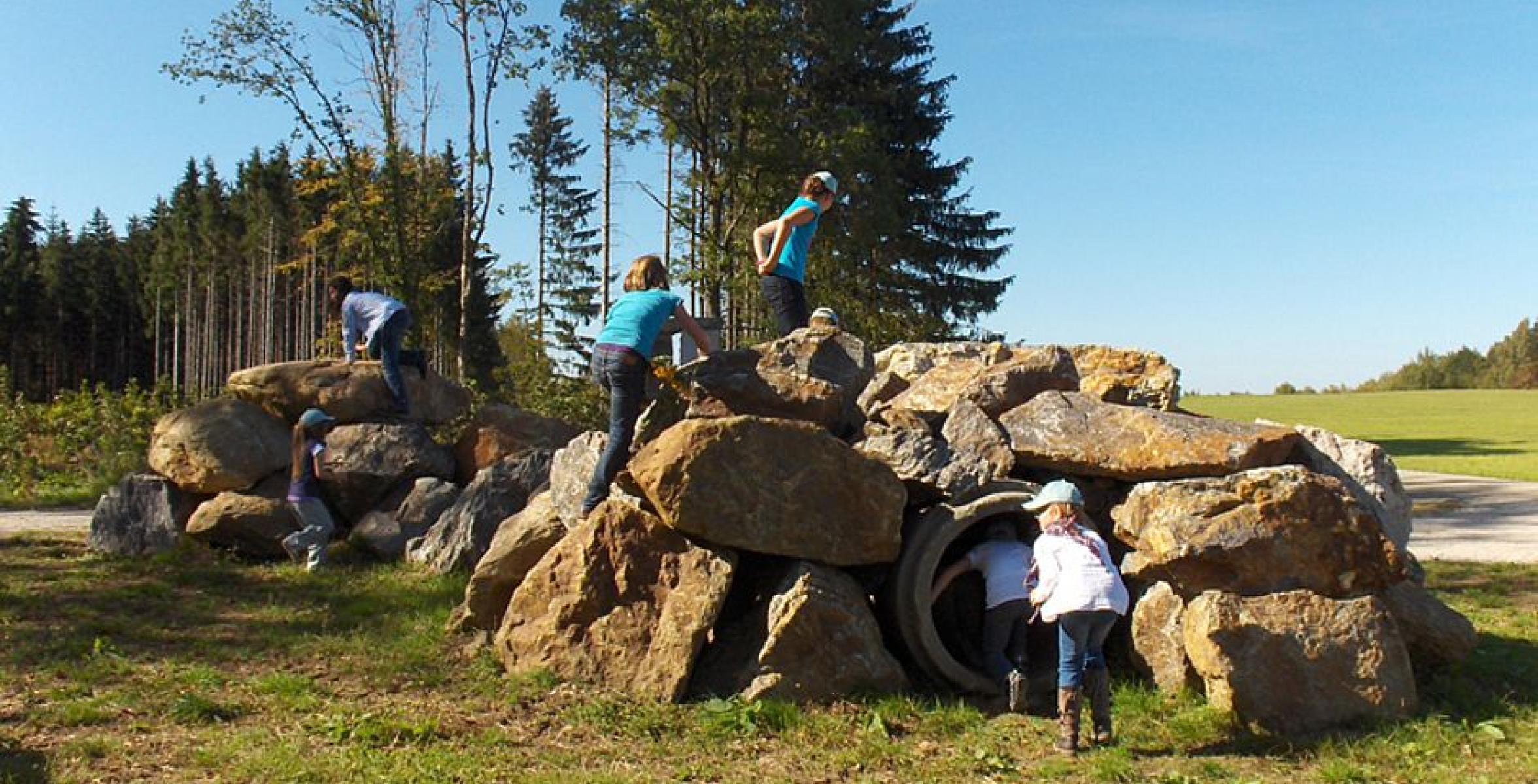 Kinder spielen auf Gestein