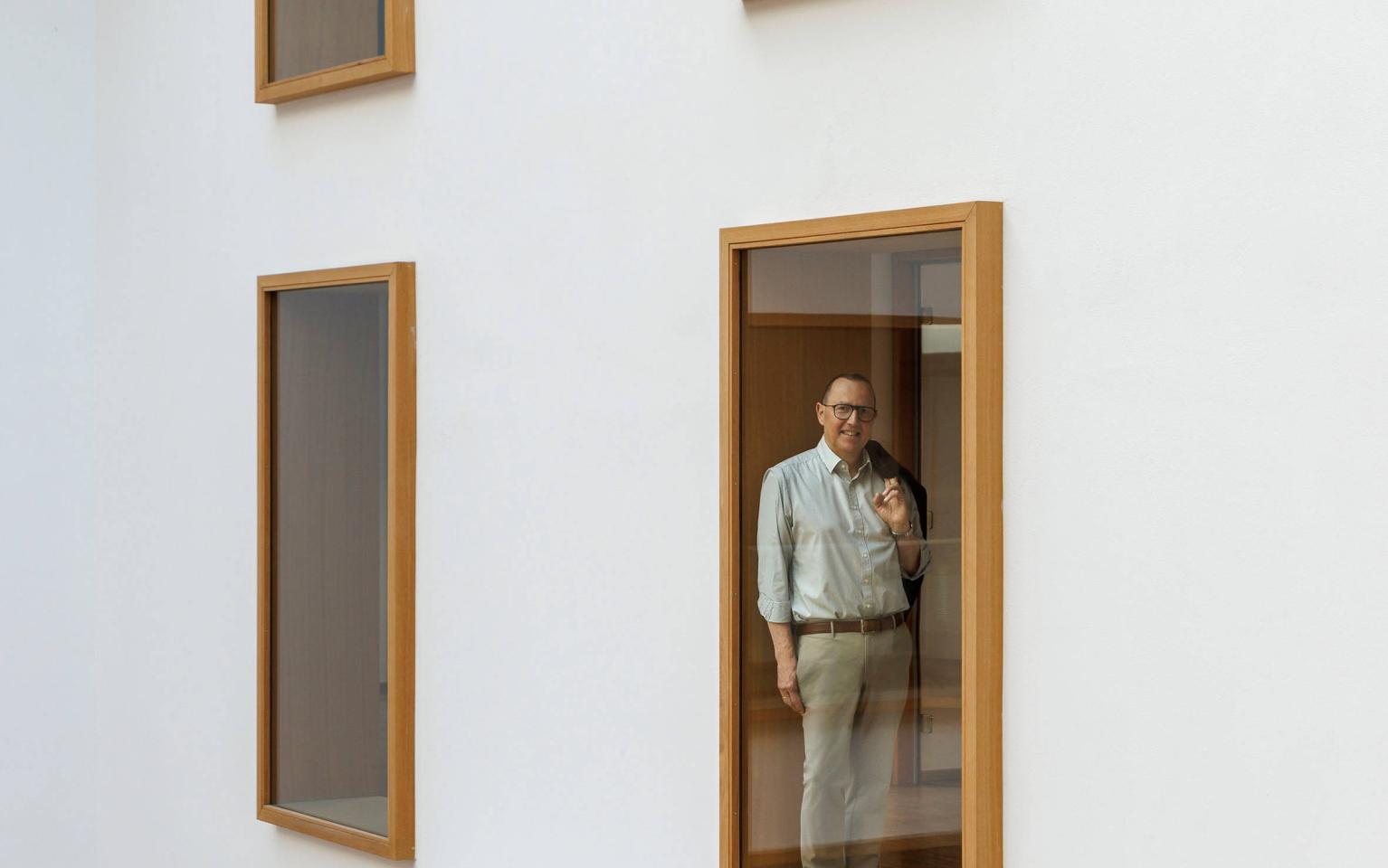 Mann in Bürogebäude vor Glasscheibe