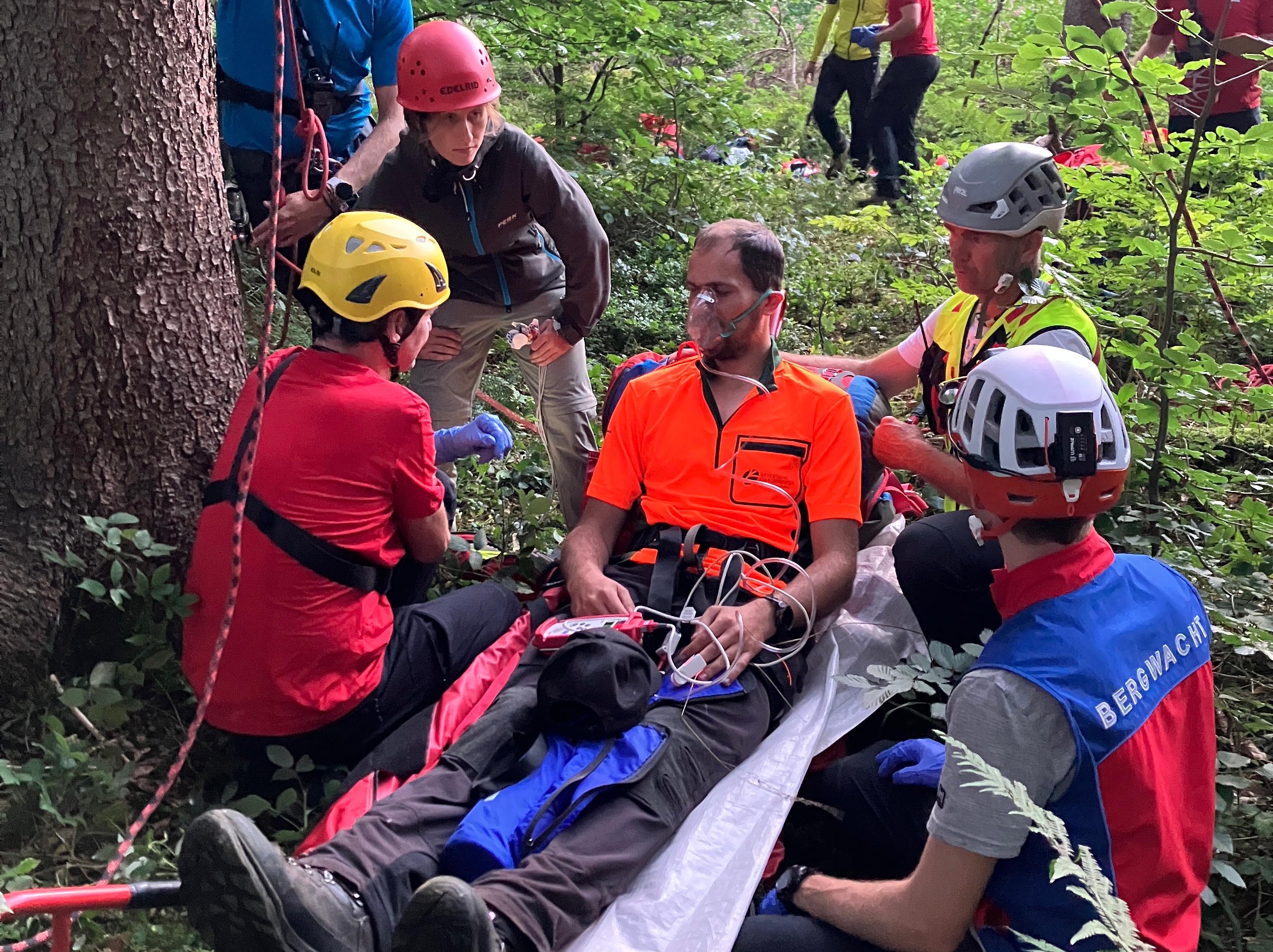 Rettungsübung: Förster auf einer Liege umgeben von Mitgliedern der Bergwacht