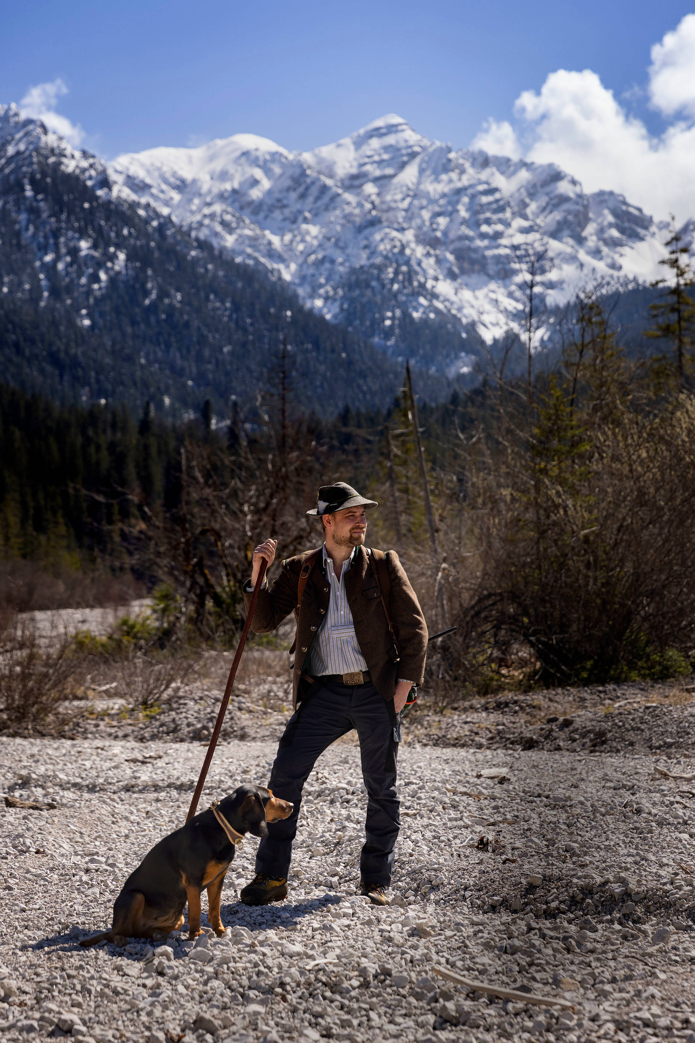 Berufsjäger mit Hund vor Berg
