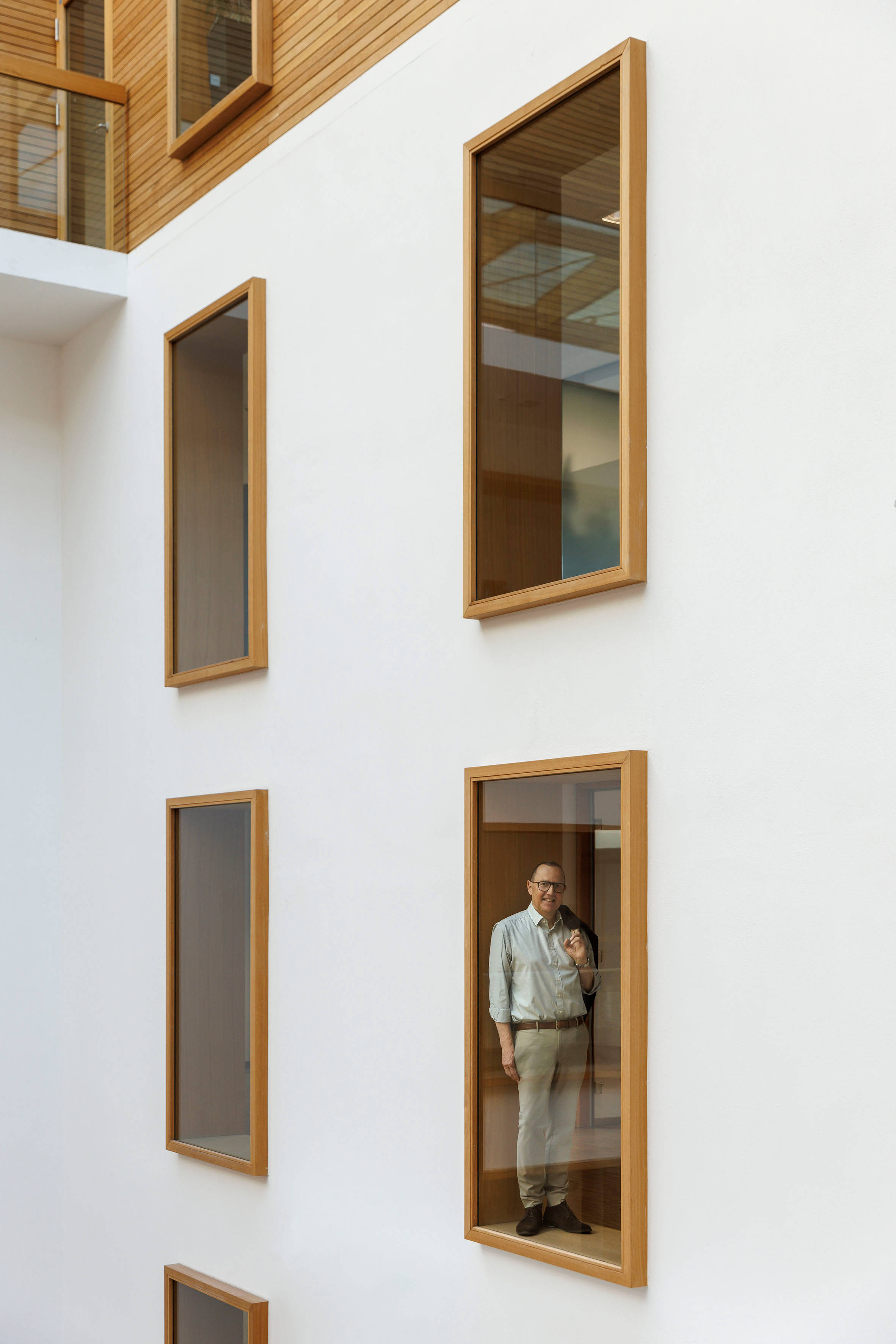 Mann in Bürogebäude vor Glasscheibe