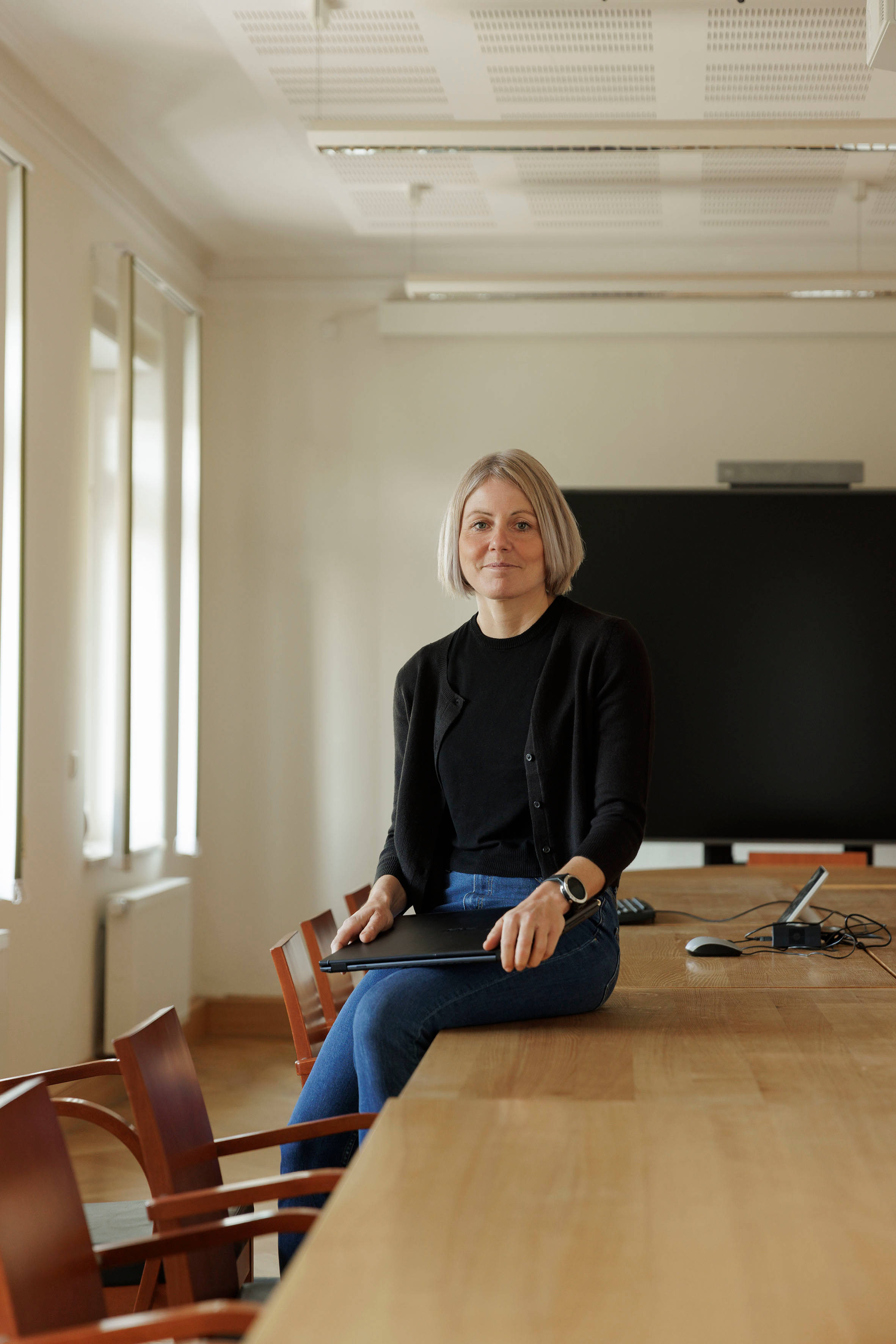 Frau auf Besprechungstisch mit Laptop