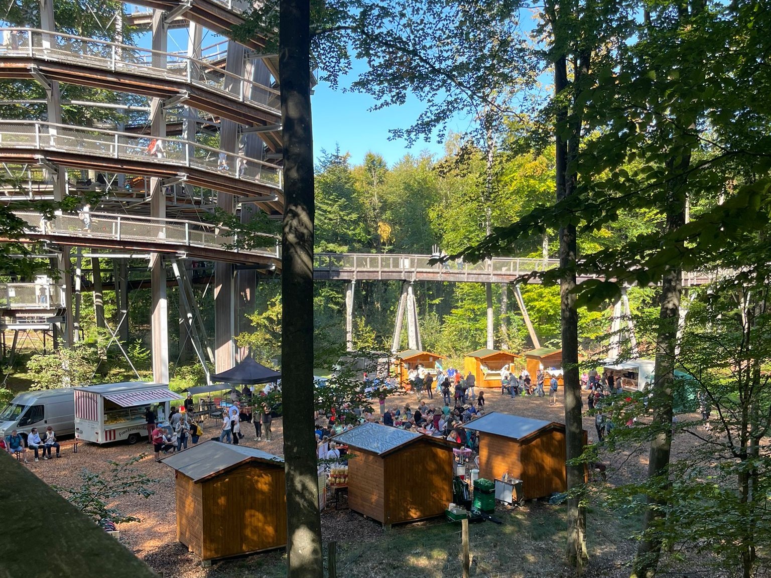 Buden und Marktstände im Wald um den Baumwipfelpfad Steigerwald, buntes Treiben in der Natur