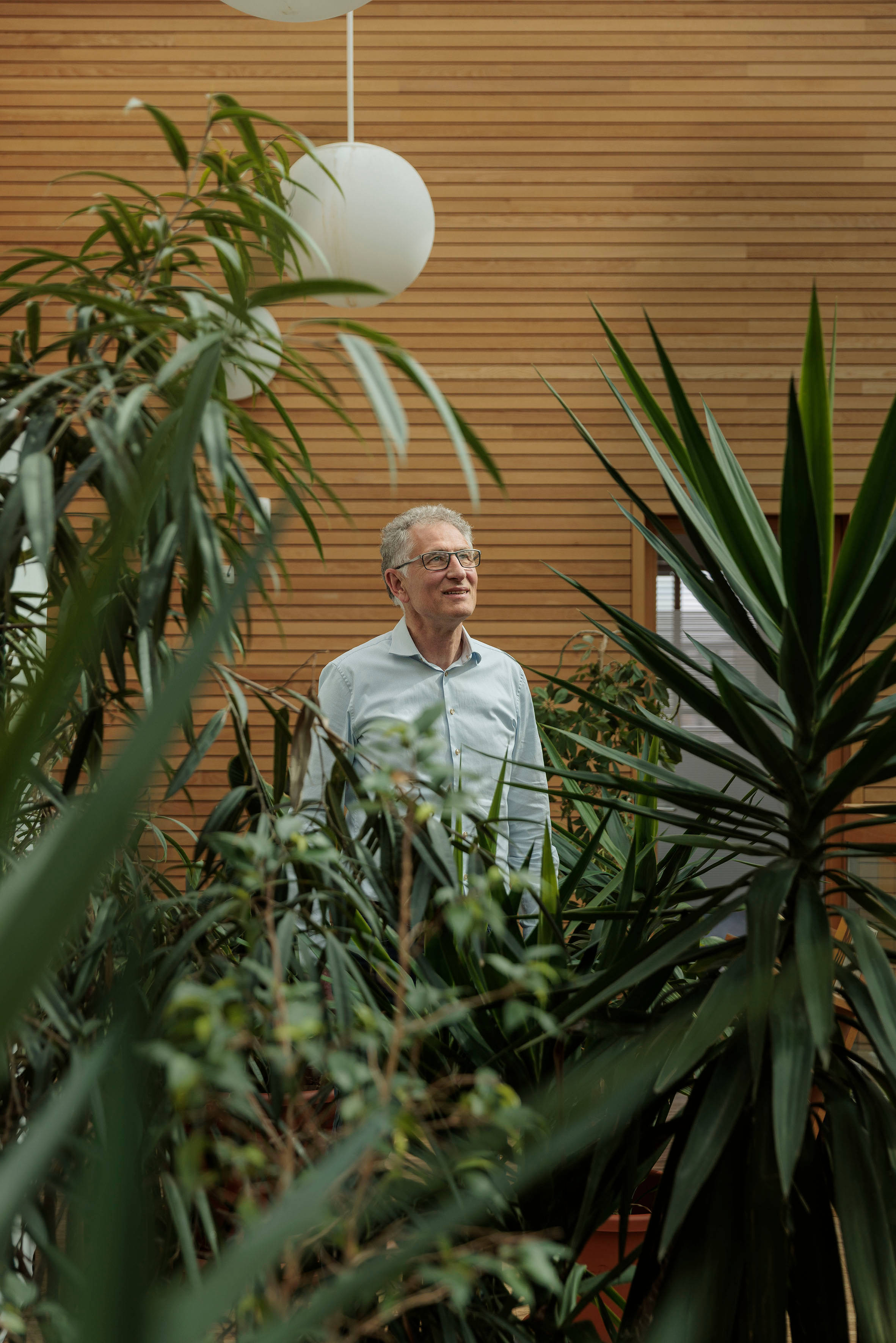Förster steht vor Pflanzen in Bürogebäude