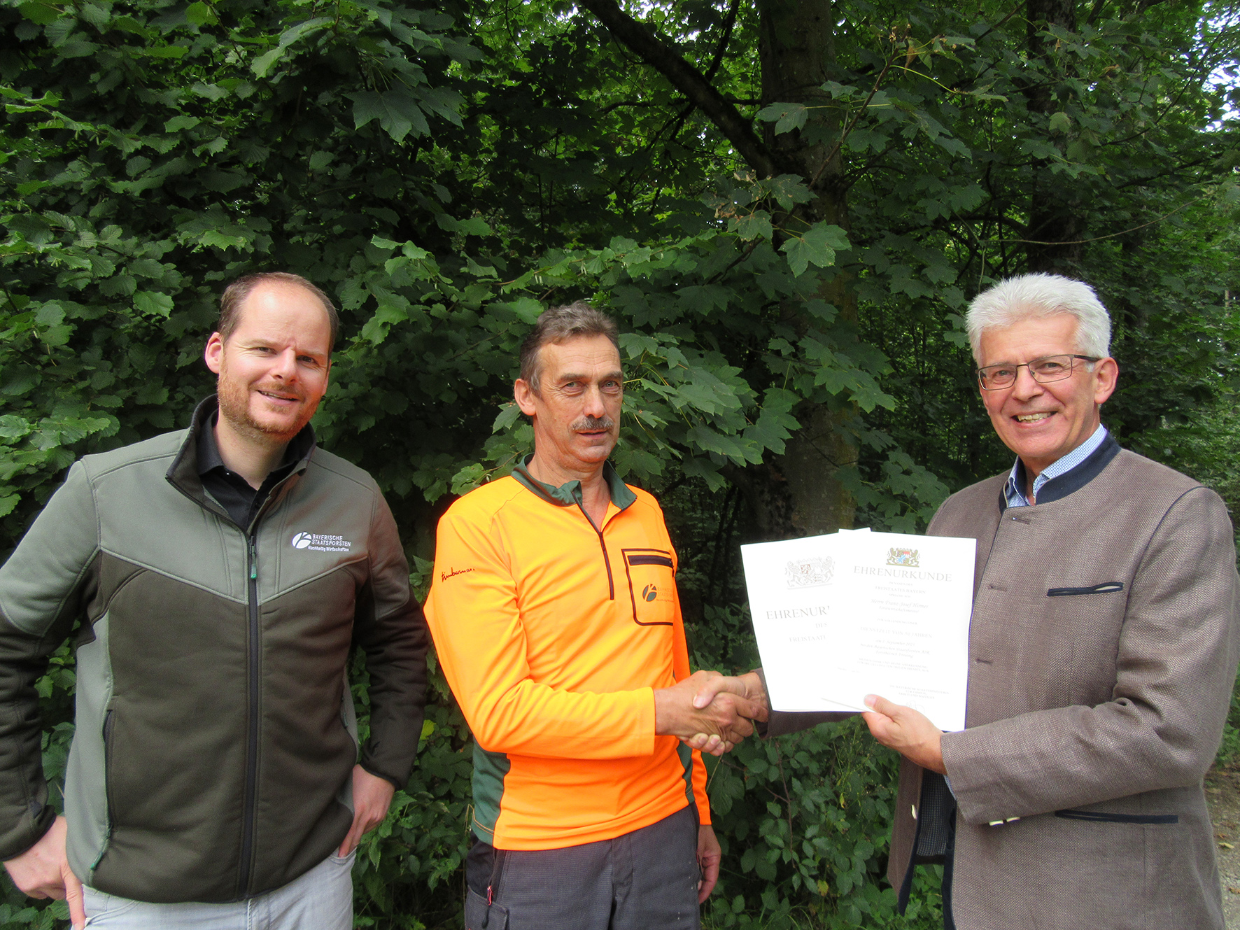 Dr. Alfred Fuchs und Tobias Sommer gratulieren Hr. Hirmer und überreichen eine Urkunde