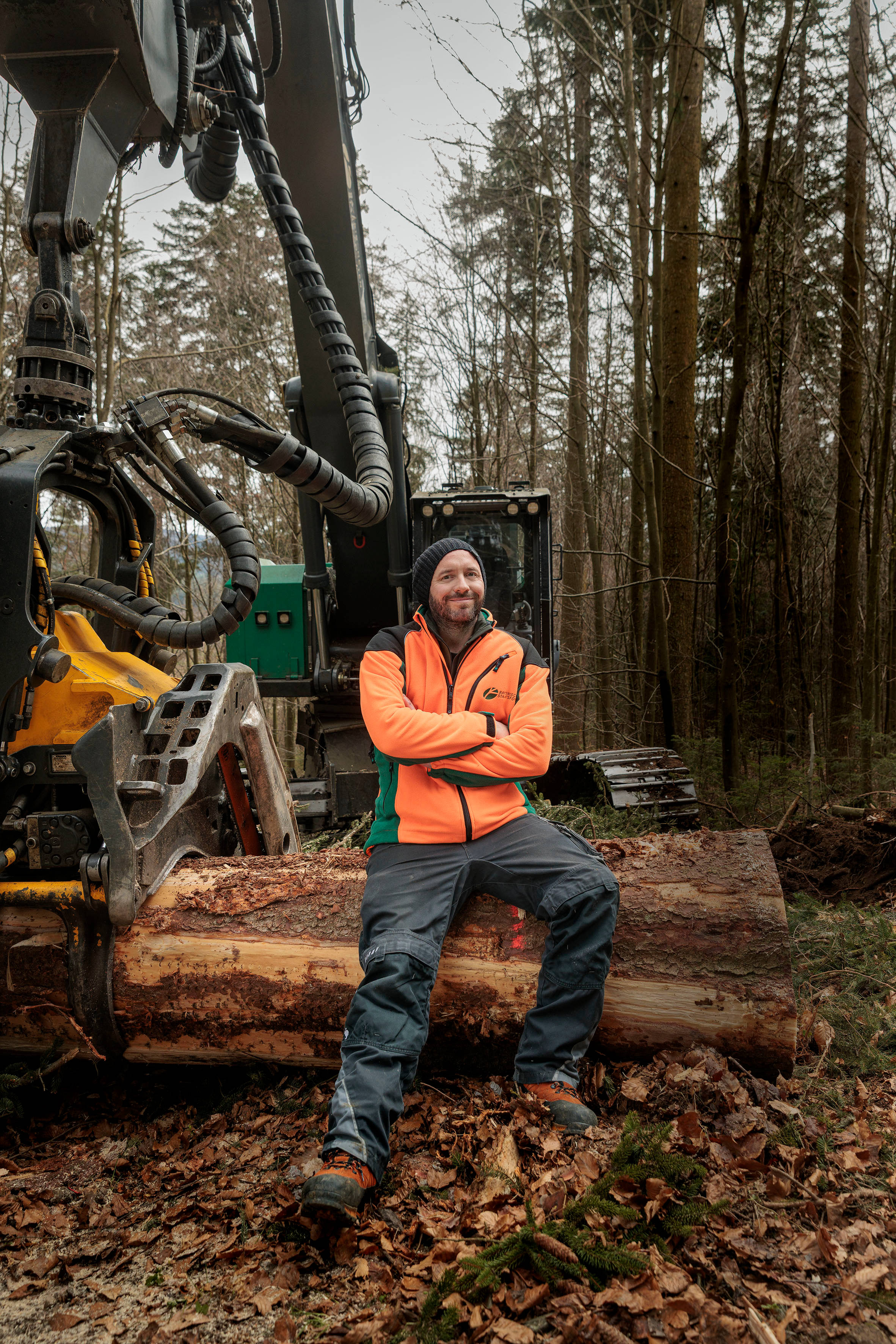 Forsttechniker sitzt auf Harvester im Wald
