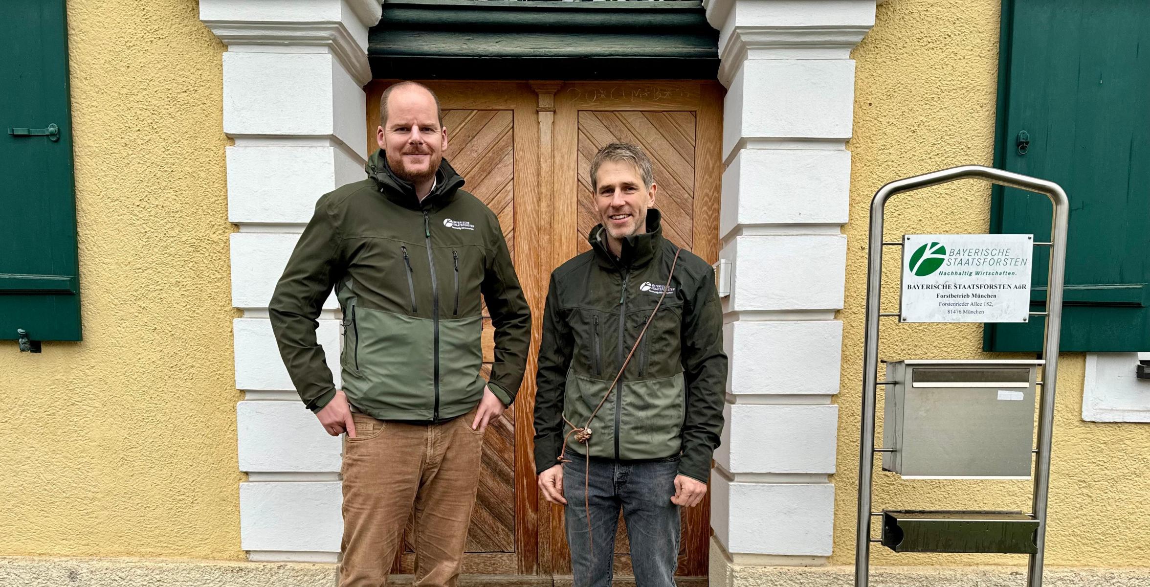 Zwei Menschen vor Haus mit Hund