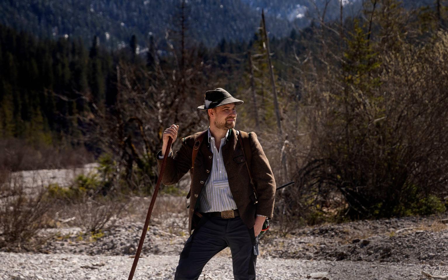Berufsjäger mit Hund vor Berg
