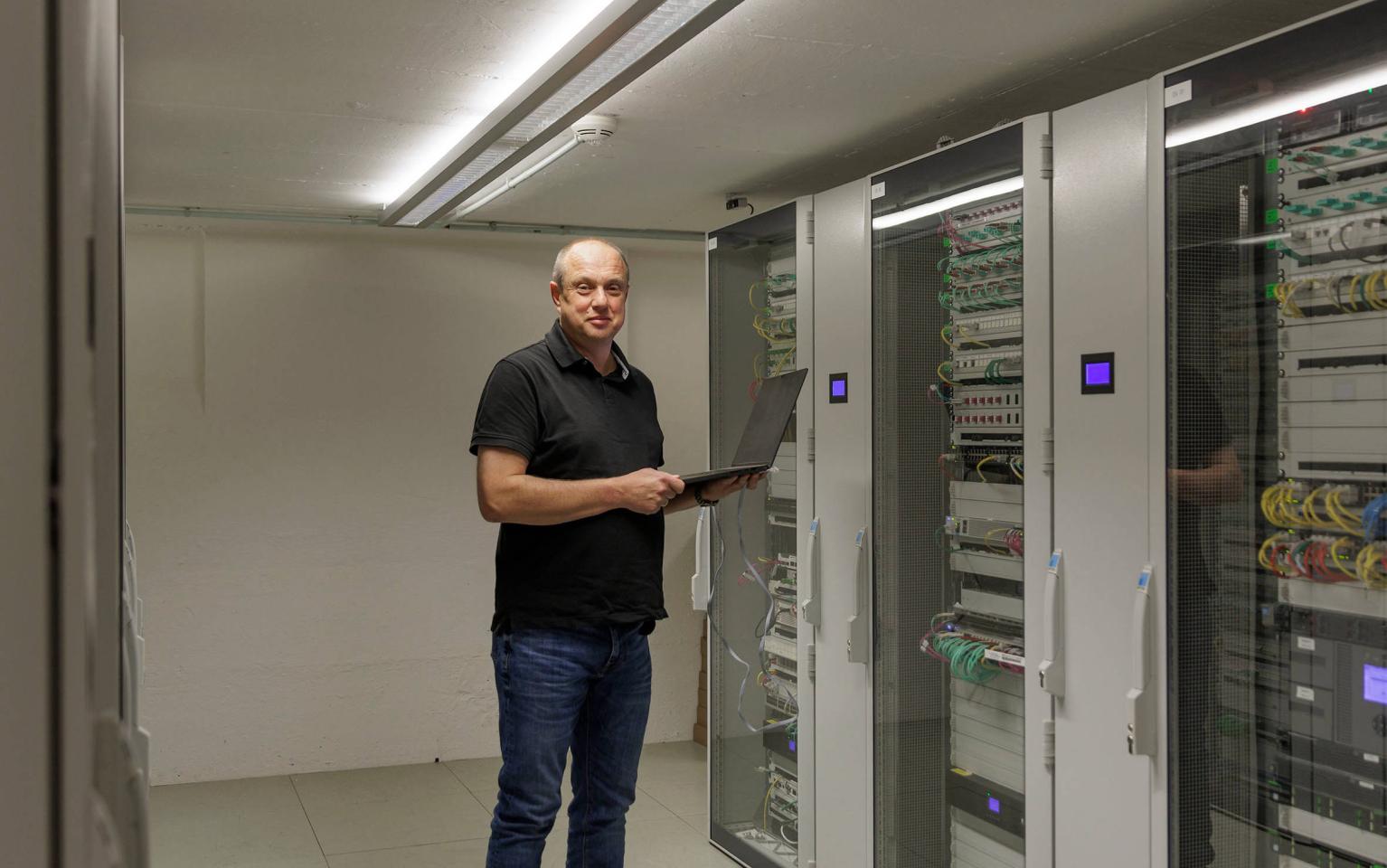 IT-Spezialist steht vor Servern in Keller