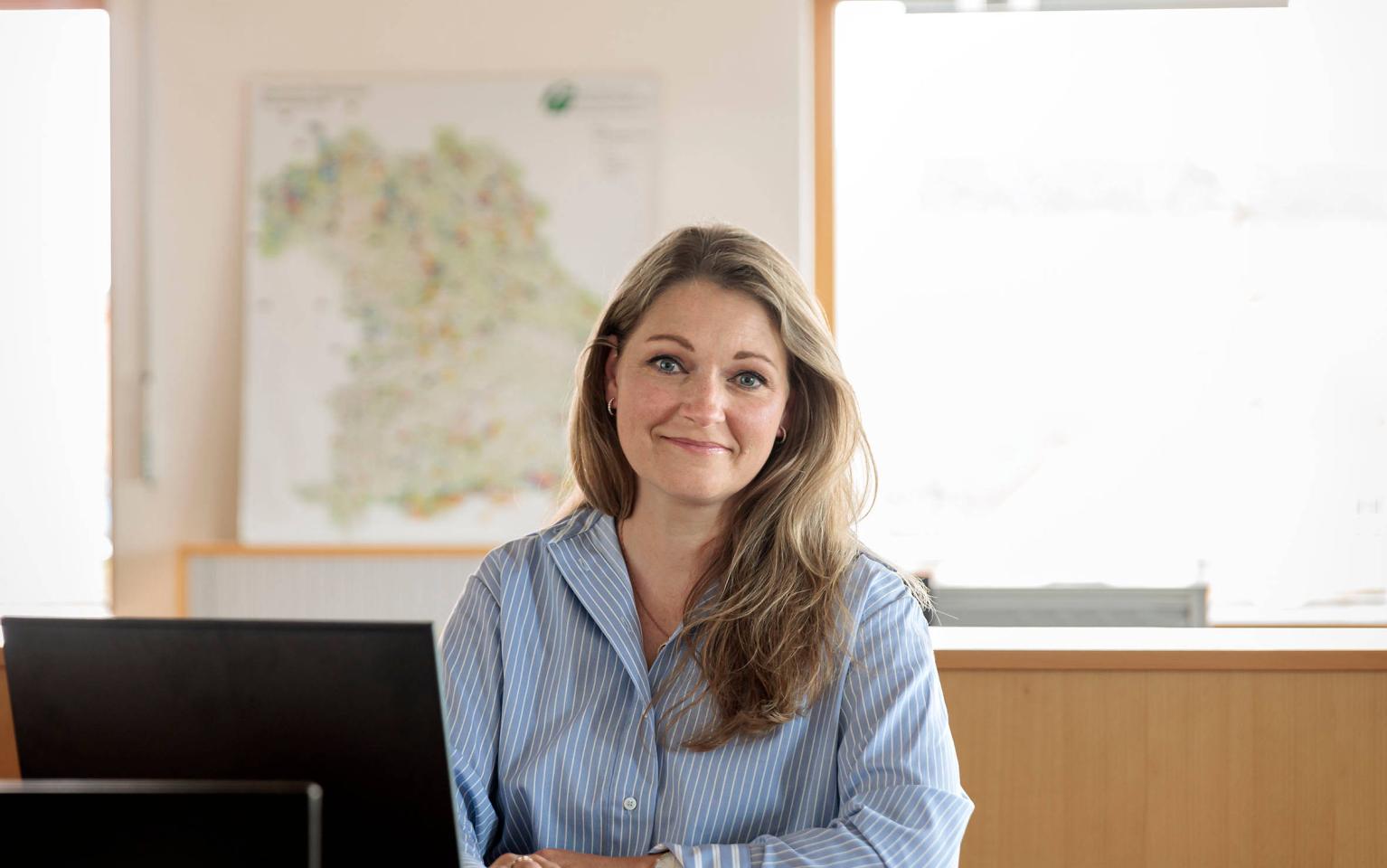 Frau hockt in Büro am Schreibtisch